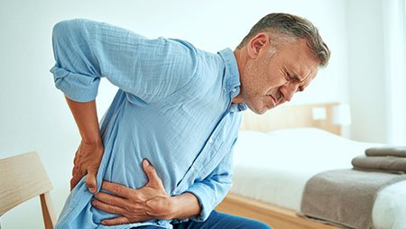 Мужчина держится за левый бок